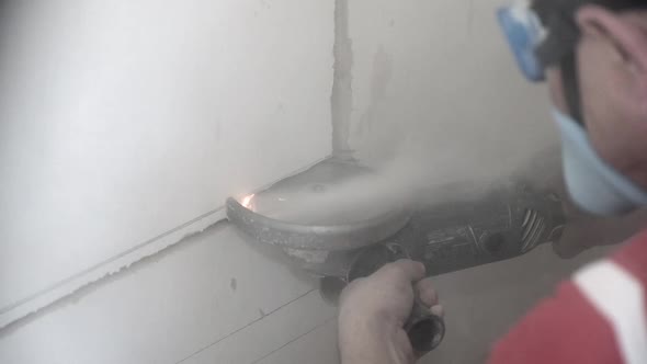 Builder Cuts Piece of Wall with Disk Saw at Repairing Works