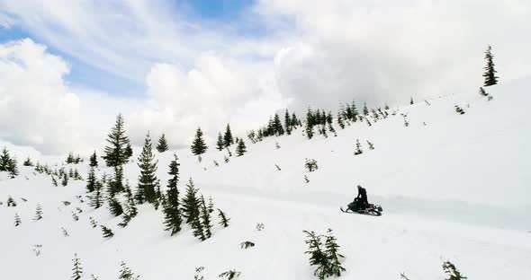 Snowmobile Action Speeding Down Cattrack Trail Winter Scene Traveling Mountain Forest Aerial alt