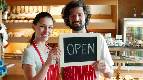 Bakers holding open signboard alt