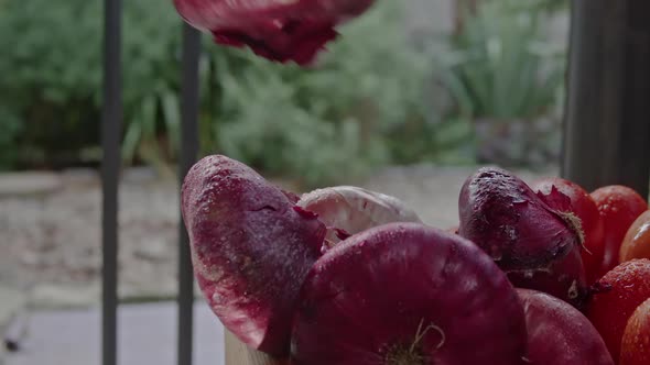 Woman's Hand Takes and Puts Back the Onion in a Box with Vegetables