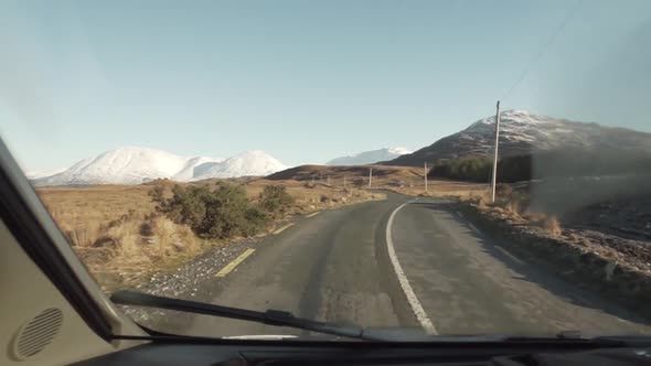 lonely-car-driving-through-mountain-location-in-ireland-by-addictive-stock