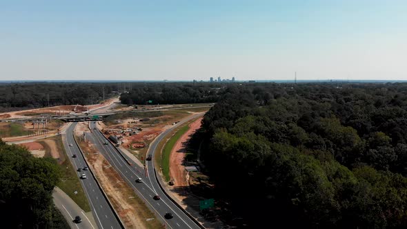 Drone shot of highway construction with downtown Raleigh North Carolina in the distance. alt
