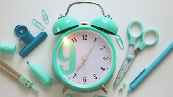 Alarm clock ringing. Blue alarm clock with school supplies, accessories. 