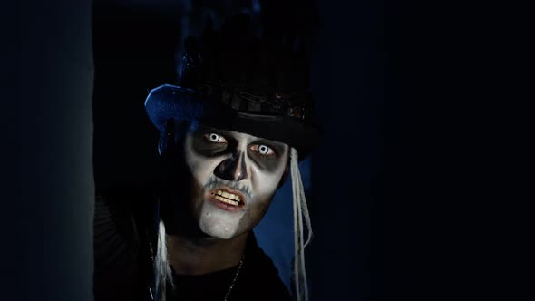 Sinister Man with Halloween Skeleton Makeup Quickly Appears From Dark Corner, Trying To Scare alt
