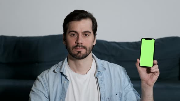 Close-Up Of a man with Glasses Using a Smartphone with a Green screen Online alt