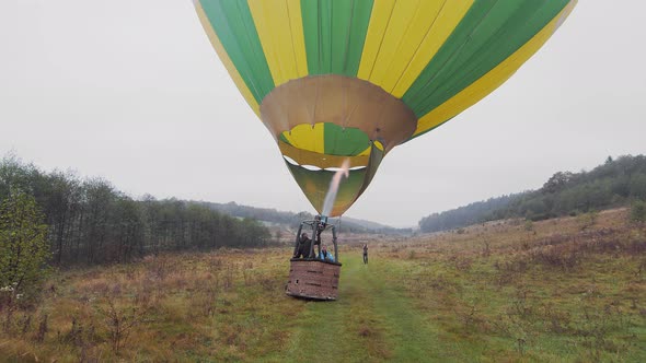 Travelers Inflate the Balloon with Warm Air and Prepare to Fly in a Balloon Above the Clouds alt