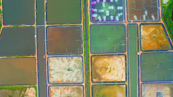 An aerial view over a drone flying over a large shrimp farm alt