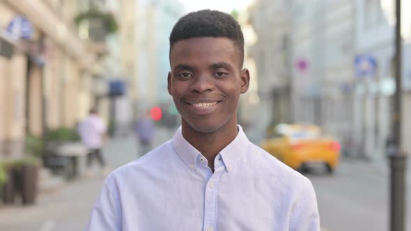 Portrait of African Man Showing Thumbs Up Sign Outdoor alt