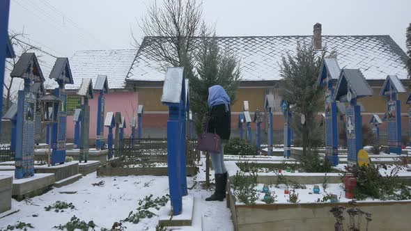 Woman looking at a gravestone alt