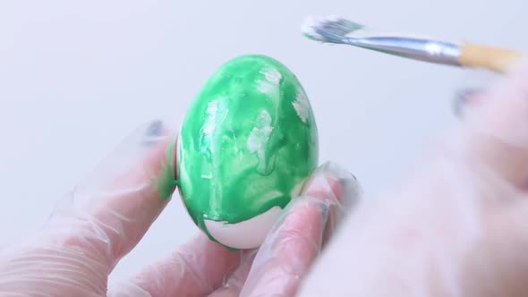 Closeup of a Person Painting Easter Eggs with a Special Brush alt