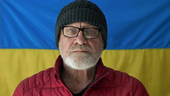 Elderly Grayhaired Man Against the Background of the Flag of Ukraine