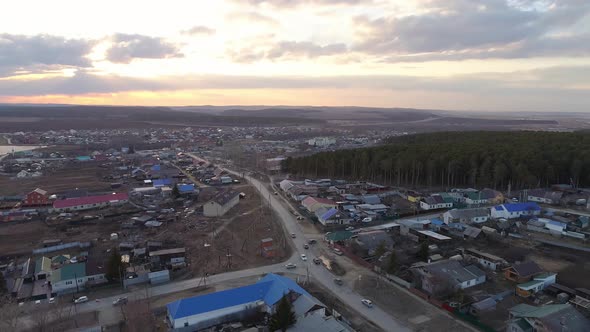 Aerial view of Spring evening in the village. Cars are driving along the road 11 alt