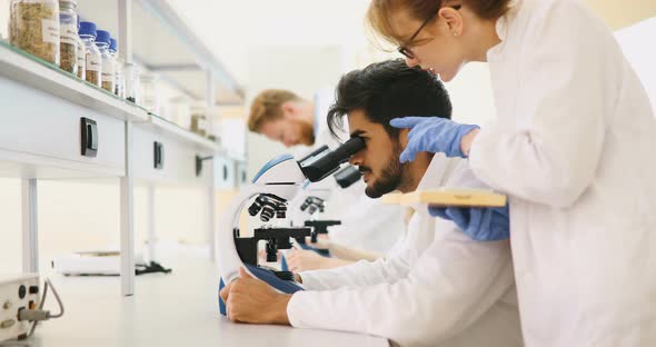 Young Scientist Looking Through Microscope in Laboratory