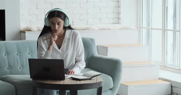 Concentrated Young Woman Teacher Using Laptop and Webcam to Distant Learning alt