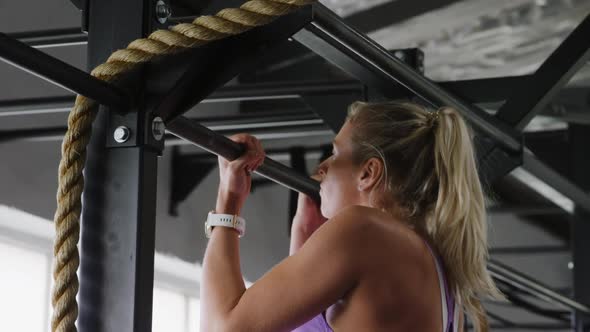 Side view athletic Caucasian woman doing chin ups alt