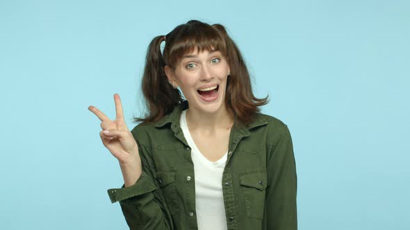 Slow Motion of Cheerful Funny Woman with Double Ponytail Hairstyle Smiling Happy and Showing Peace