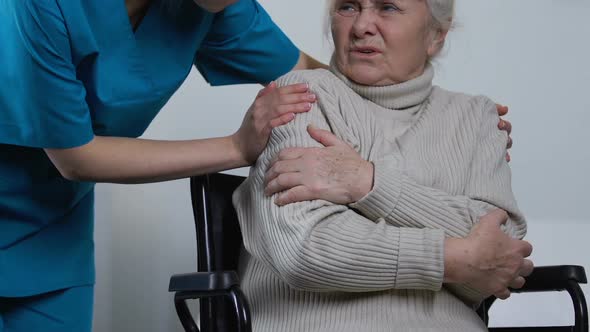 Helpful Young Nurse Covering Disabled Lady in Wheelchair With Warm Plaid, Care alt