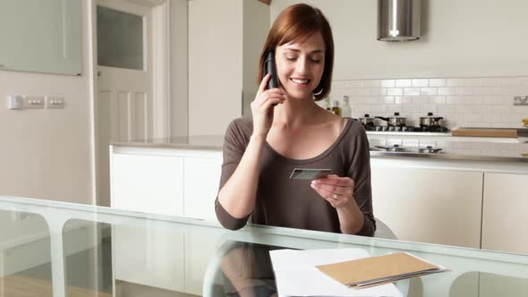 Woman on telephone with credit card alt