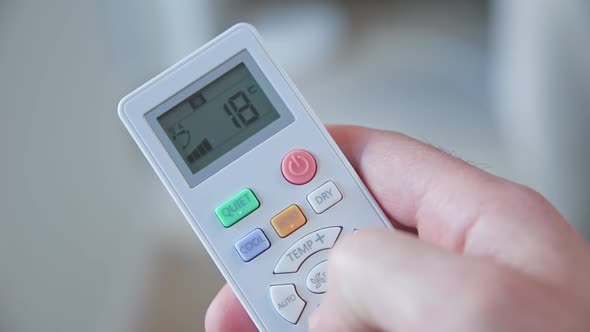 Hand Adjusting Temperature on Air Conditioner alt