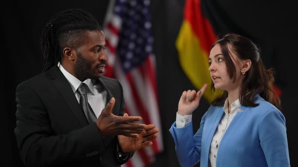 African American and Caucasian Diplomats Arguing at Press Conference with USA and German Flags at alt
