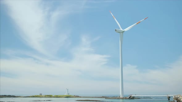 Blue sky and sea and wind turbine. Green energy and environment. alt