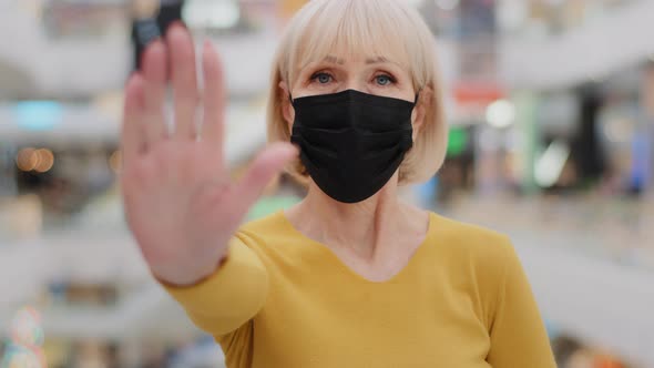Serious Middleaged Caucasian Woman in Medical Mask Protects Health Holding Hand in Front Put Palm alt