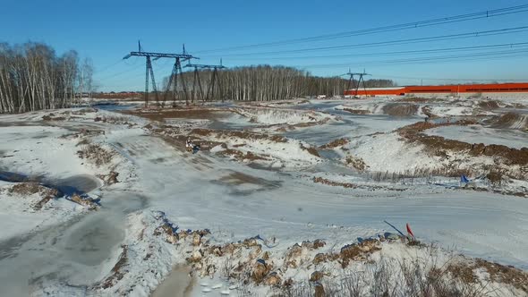 a motorcyclist performs stunts on a winter track alt