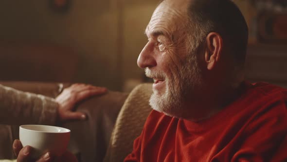 Aged Husband with Tea Listening to Wife alt