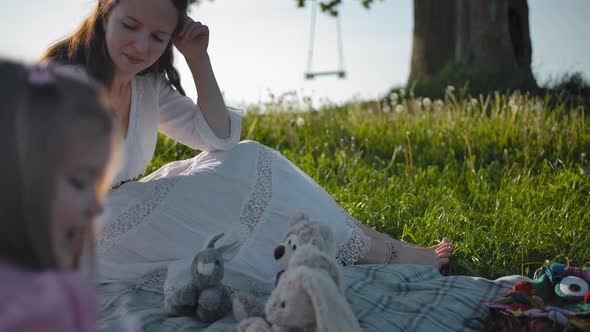 A Young Mother and Her Two Little Daughters Made a Picnic in a Clearing Near a Lonely Old Oak alt