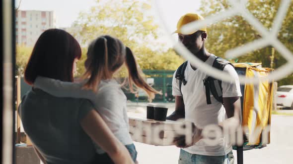 Portrait of an African American Courier with a Thermal Bag and Pizza Near the alt