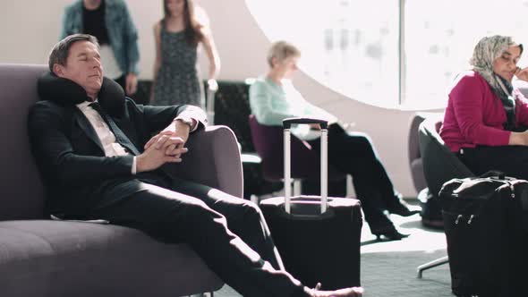 Adult business male sleeping in airport waiting lounge