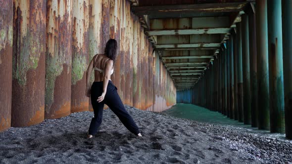 a Barefoot Woman Dances Under the Pillars of the Bridge alt