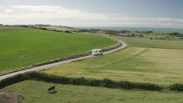 Aerial view of motorhome on country road. alt