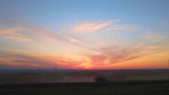 Tractor Spraying Fertilizers with Insecticide Herbicide Chemicals on Agricultural Field at Sunset alt