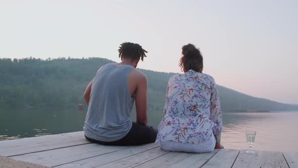 Couple Enjoying Lake View and Talking on Pier alt