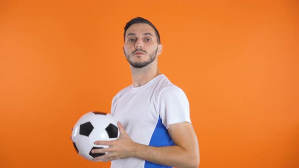 Happy Confident Football Player in White Blue Shirt Throwing in Air Soccer Ball alt