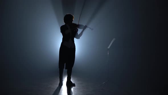Girl Plays the Violin and Looks at the Music Stand in the Dark  alt