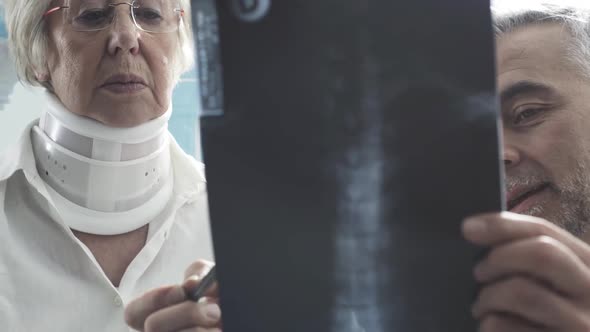 Doctor examining an injured senior woman with cervical collar