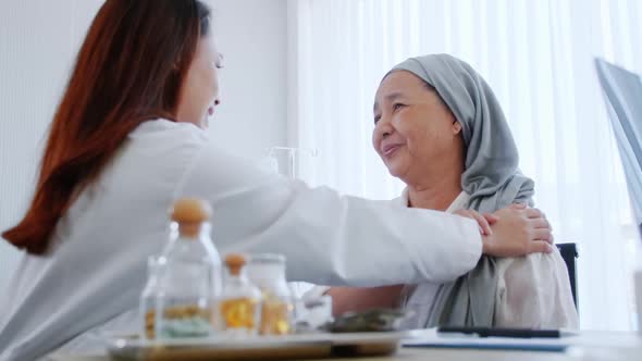 A specialist doctor is talking to an Asian elderly woman after recovering from cancer treatment. alt