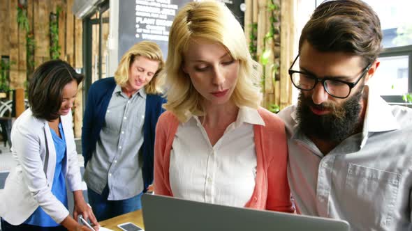 Friends discussing over laptop alt