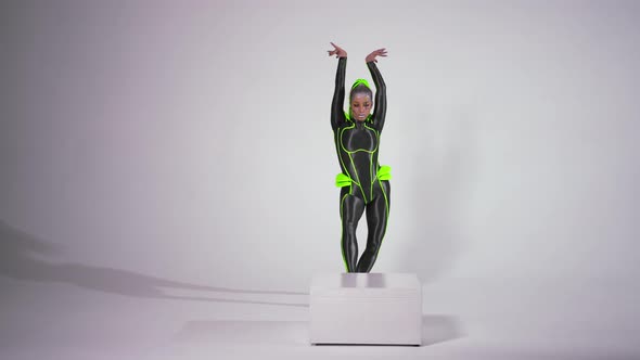 Wide Shot Portrait of Confident Gymnast in Futuristic Costume Doing Front Walkover and Looking at alt