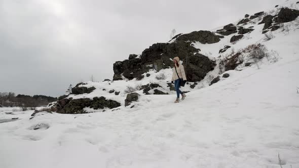 A Young Girl Descends From a Mountain Down Overlooking the Winter Forest