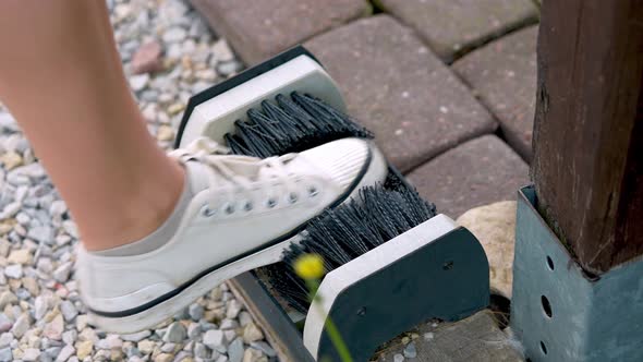 A Girl Cleans Shoes on the Street with a Special Brush alt