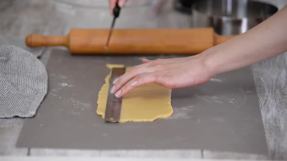 Cutting Raw Dough in Flour with a Knife