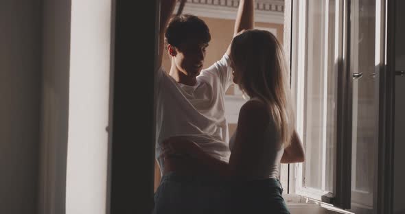 A girl is taking out the white t-shirt of his boyfriend alt