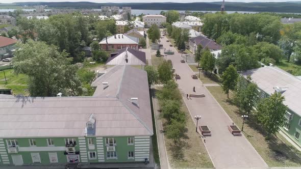 People walks along a beautiful alley in a provincial city. Poplar fluff flies 07 alt