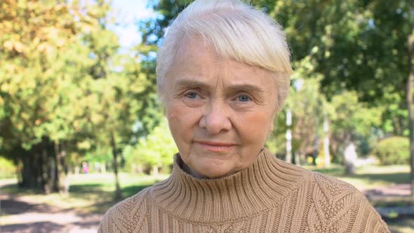 Mature Caucasian Woman Sitting Outdoors, Old Generation Wisdom, Peaceful Rest