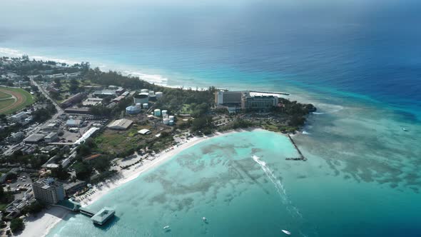 Aerial shot of yacht sailing to a white sandy beach at the edge of Bridgetown, Barbados alt
