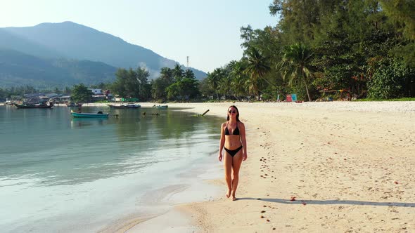 Young fun women travelling having fun on the beach on clean white sand and blue 4K background alt