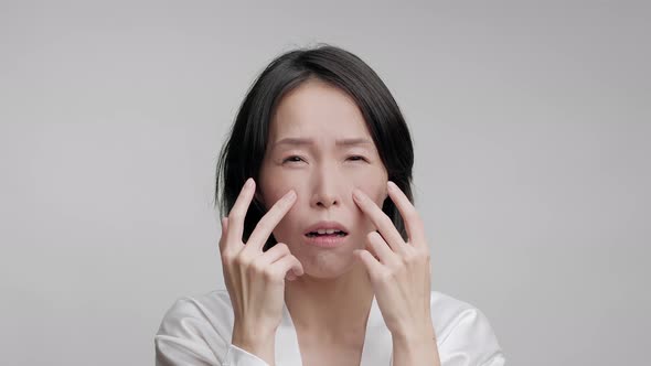 Korean Mature Woman Touching Face Making Facial Massage Gray Background alt